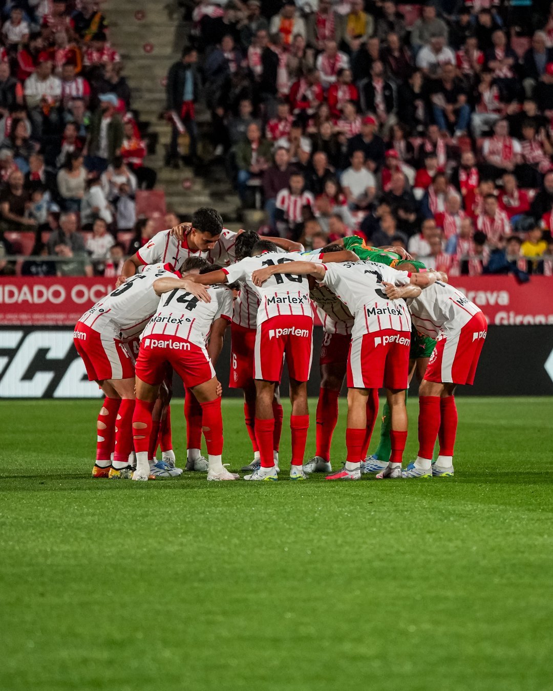 los jugadores del GironaFC abrazados y haciendo la charla interna
