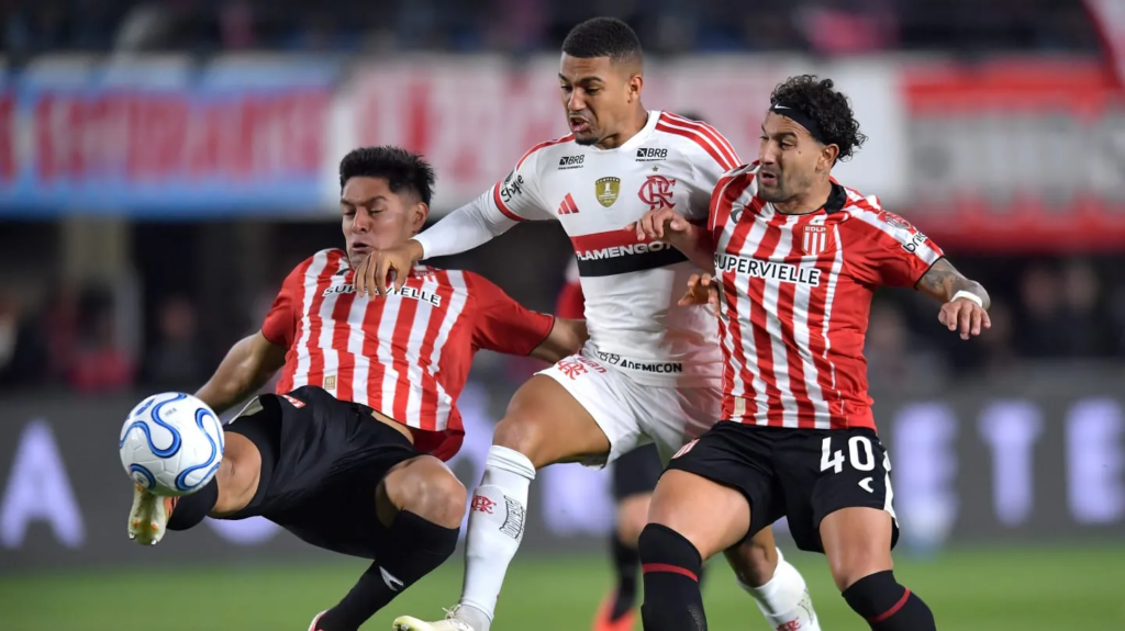 Dos jugadores de Estudiantes interceptando a un futbolista del Flamengo en un partido de las semifinales de la Copa Libertadores en el Estadio UNO